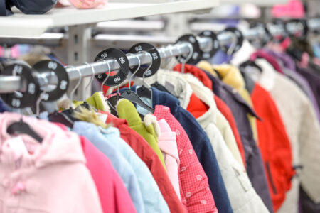 Kinderkleidung auf Kleiderbügeln.
